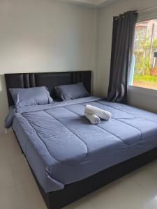 GN House Bangtao في Ban Thalat Choeng Thale: سرير عليه وسادة بيضاء