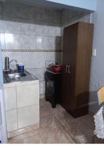 a small kitchen with a sink and a stove at Duplex En Iguazu in Puerto Iguazú