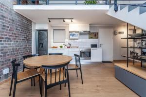 una cucina aperta e una sala da pranzo con tavolo e sedie di Stylish Cape Town Penthouse a Città del Capo