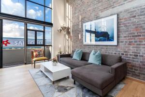 un soggiorno con un divano e un muro di mattoni di Stylish Cape Town Penthouse a Città del Capo