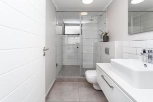 un bagno bianco con doccia e WC di Stylish Cape Town Penthouse a Città del Capo Altre 6 foto