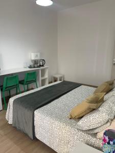 a bedroom with a bed with two green chairs at Camera comfort matrimoniale con bagno e zona cottura in Chiavari