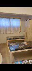 a small kitchen with two tables and a window at Vyavasthapan hostels in Pune