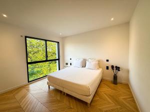 a bedroom with a large bed and a window at Les Trois Cyprès in Blois