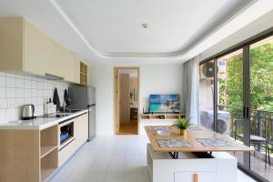 a kitchen with a table and a counter top at Fantasea Condo Kamala A503 2BDRM by Phuket Sabay Rent in Kamala Beach