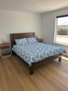 a bedroom with a bed and a window at Newly Renovated Coastal Retreat in Port Kenny