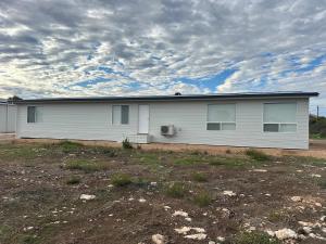 a white house with windows on the side of it at Newly Renovated Coastal Retreat in Port Kenny