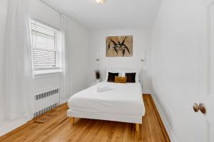 a white bedroom with a bed and a window at Designer Home with 3BR Retreat mins to NYC in Yonkers