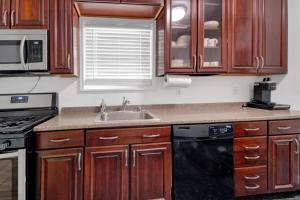 a kitchen with wooden cabinets and a sink at Designer Home with 3BR Retreat mins to NYC in Yonkers
