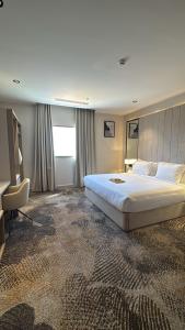 a hotel room with a large bed and a chair at فندق حياة تاون حقل in Ḩaql +46 photos