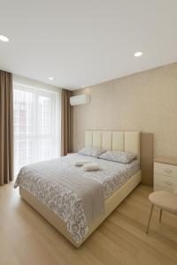 a bedroom with a large bed and a large window at Sky Crown Batumi in Angisa