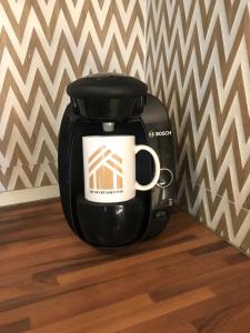 a black coffee pot sitting on a wooden floor at LM APARTAMENTOS Dos mares in Motril