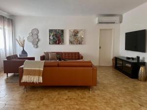 un salon avec un canapé et une télévision à écran plat dans l'établissement Blue Skies Villas 1&2, à Mexilhoeira Grande