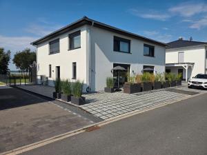 a white house with potted plants on a street at Ferienhaus Schlossterrassen 8a in Pouch