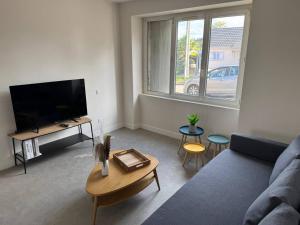 a living room with a couch and a tv at Logis Le Pagnon in Brive-la-Gaillarde