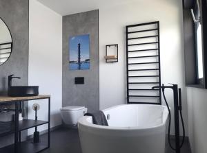 a bathroom with a white tub and a toilet at Ferienhaus Schlossterrassen 8a in Pouch +37 photos