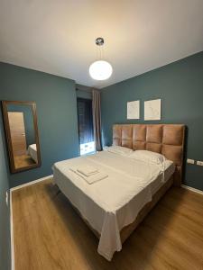 a bedroom with a large bed and a mirror at Kalpazo Tirana Mosaic in Tirana