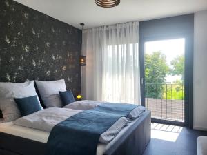 a bedroom with a bed and a large window at Ferienhaus Schlossterrassen 8a in Pouch