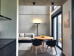 a kitchen and a living room with a table and chairs at Ferienhaus Schlossterrassen 8b in Pouch