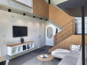 a living room with a couch and a tv at Ferienhaus Schlossterrassen 8b in Pouch