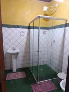 a bathroom with a shower with a sink and a toilet at Pousada Pé do Morro in Vale do Capao