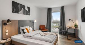 a bedroom with a bed and a desk and a chair at smartments Bielefeld Hauptbahnhof in Bielefeld