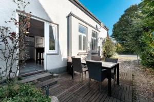 a wooden deck with a table and chairs on a house at Insel Hus in Fehmarn