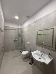 a bathroom with a toilet and a sink and a shower at Palita Vita - Durrës Beach in Durrës +23 photos