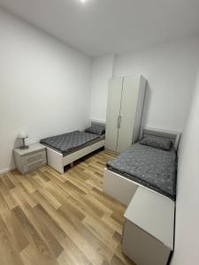 two beds in a room with wooden floors at Palita Vita - Durrës Beach in Durrës