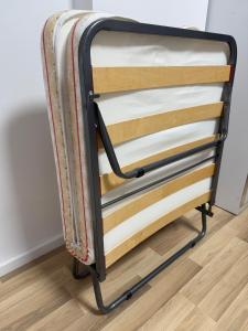 a metal bed frame on a wooden floor at Palita Vita - Durrës Beach in Durrës