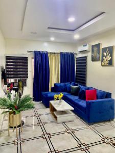 a living room with a blue couch and a table at Apartment cattleya in Ikeja