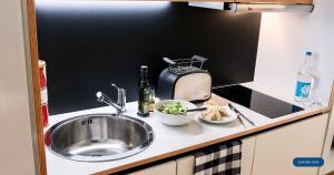a kitchen counter with a sink and a toaster at smartments Bielefeld Hauptbahnhof in Bielefeld