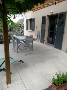 a patio with a table and chairs next to a house at La maison des cigognes Eguisheim in Eguisheim