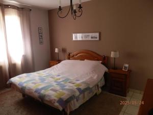 a bedroom with a bed with a comforter and a window at La maison des cigognes Eguisheim in Eguisheim