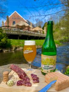 GussigniesにあるGîte du Marquisのグラスのあるテーブルの横に置かれたビールの瓶