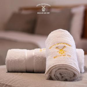 a roll of white towels sitting on top of a bed at Hotel & Restaurant Mulliri me Erë in Rahovec