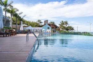 a pool at a resort with a water slide at Apto 3 Quartos Condomínio Resort Completo Pé na areia com Piscina borda Infinita, Beach Tennis, Academia, Sala de Jogos, Brinquedoteca, Playground e Portaria 24H 2 Quartos com Ar-Condicionado, Churrasqueira Privativa Reserve Agora e Viva essa Experiência in Piçarras +36 photos