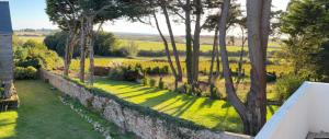 ein Bild eines Gartens mit Bäumen und Gras in der Unterkunft Villa Vieilles Vignes vue mer in Billiers