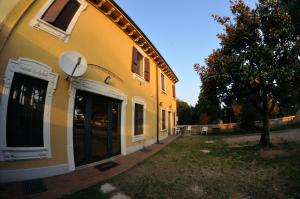 un edificio amarillo con un arco en el costado en La Magnolia, en Verona