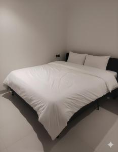 a large white bed with white sheets and pillows at شقة مريحة بأثاث جديد وعمارة جديدة قرب المطار in Riyadh