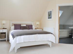 a white bedroom with a bed and a bath tub at Grieve's Cottage - Uk11107 in Montrose