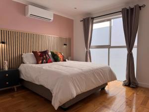 a bedroom with a large bed and a window at Urban Oasis Penthouse-Jacuzzi! in Cape Town +38 photos