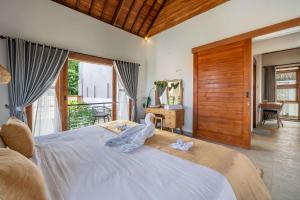 a bedroom with a large bed and a balcony at Renovated 3BR Villa in Prime Bingin Location in Uluwatu +38 photos