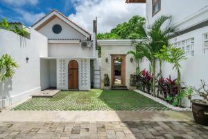 a white house with a courtyard with plants at Renovated 3BR Villa in Prime Bingin Location in Uluwatu