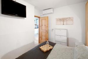a living room with a table and a tv on the wall at Ciasa de Lucky in Moena