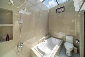 Un baño con bañera, inodoro y lavabo. en 1BR Bungalow with Kitchen & Pool in Uluwatu - B2, en Bingin Beach