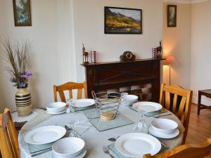 a dining room table with white dishes on it at Maesmor in Bala