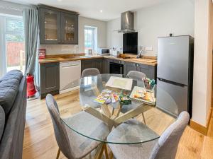 a kitchen with a glass table and chairs and a refrigerator at The Willows - Uk34000 in Child Okeford