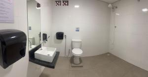 ウベルランジアにあるWEL Homeのトイレと洗面台を備えた白いバスルーム
