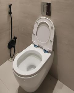 a white toilet with the seat up in a bathroom at شقة مريحة بأثاث جديد وعمارة جديدة قرب المطار in Riyadh
